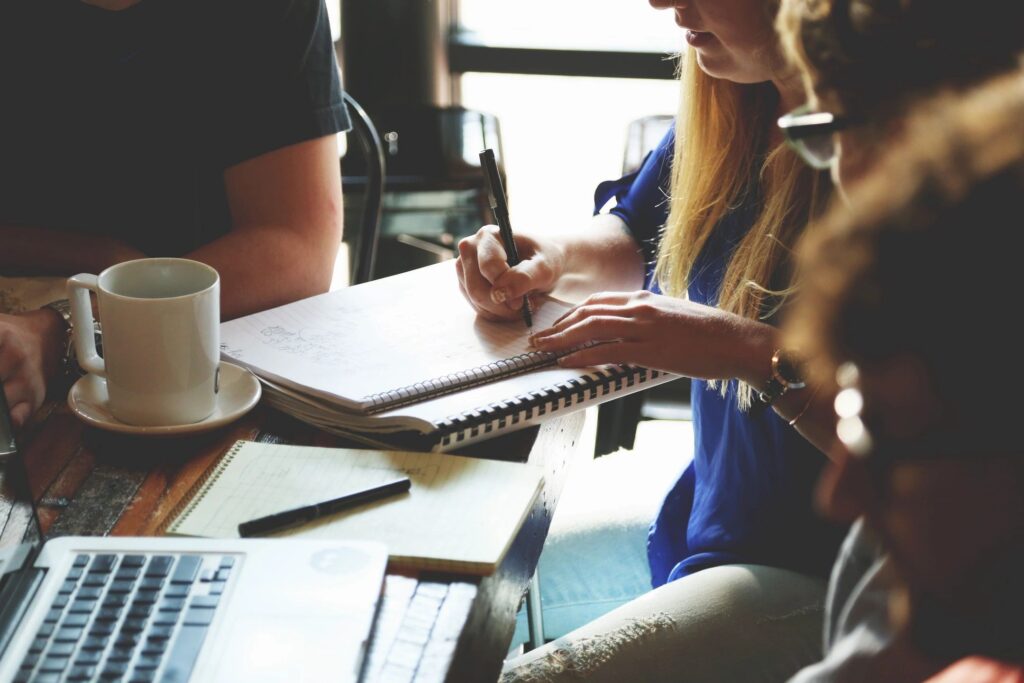 People looking at and writing notes at a table