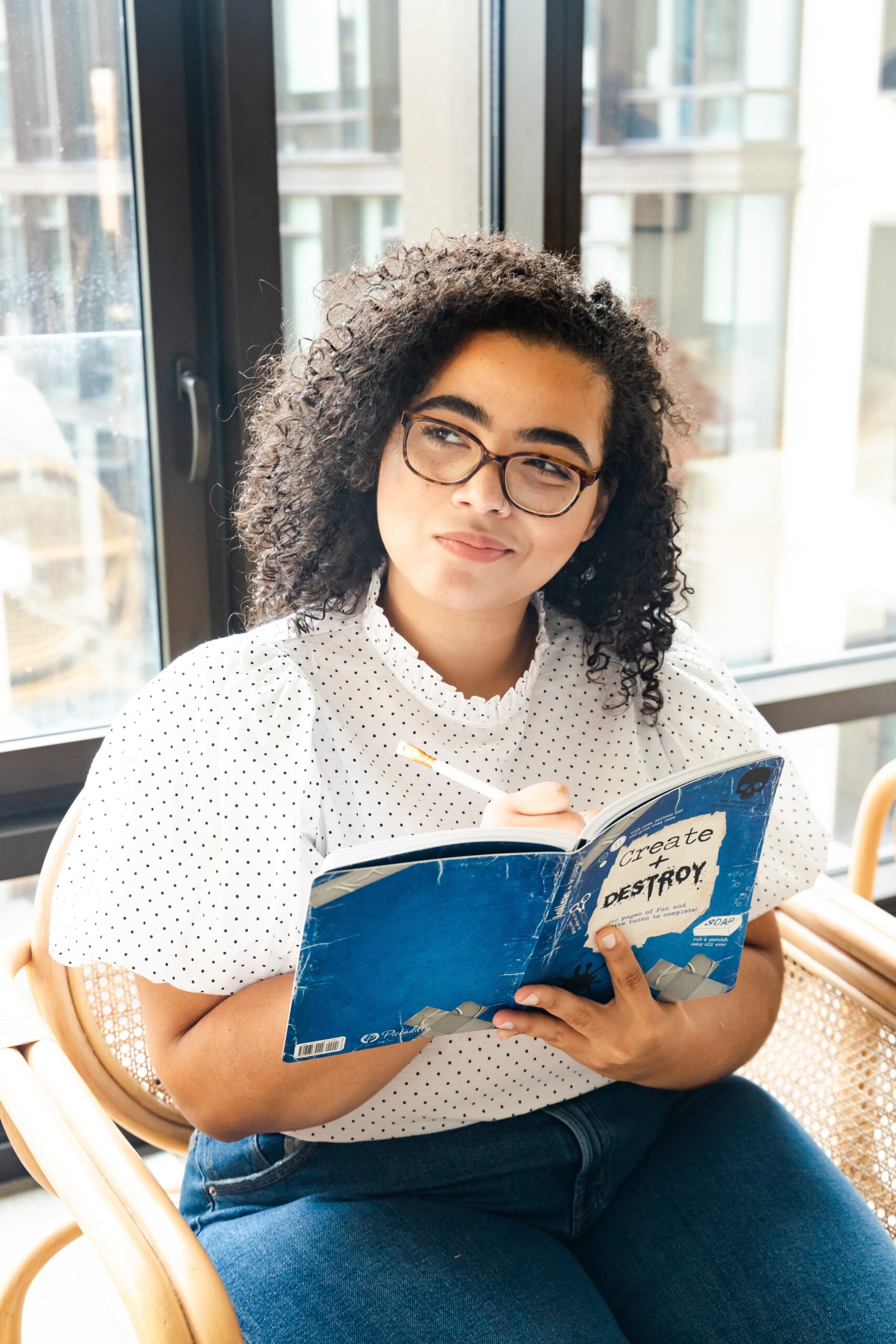 girl holding book thinking