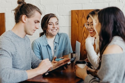 group of people smiling and looking at mobile device