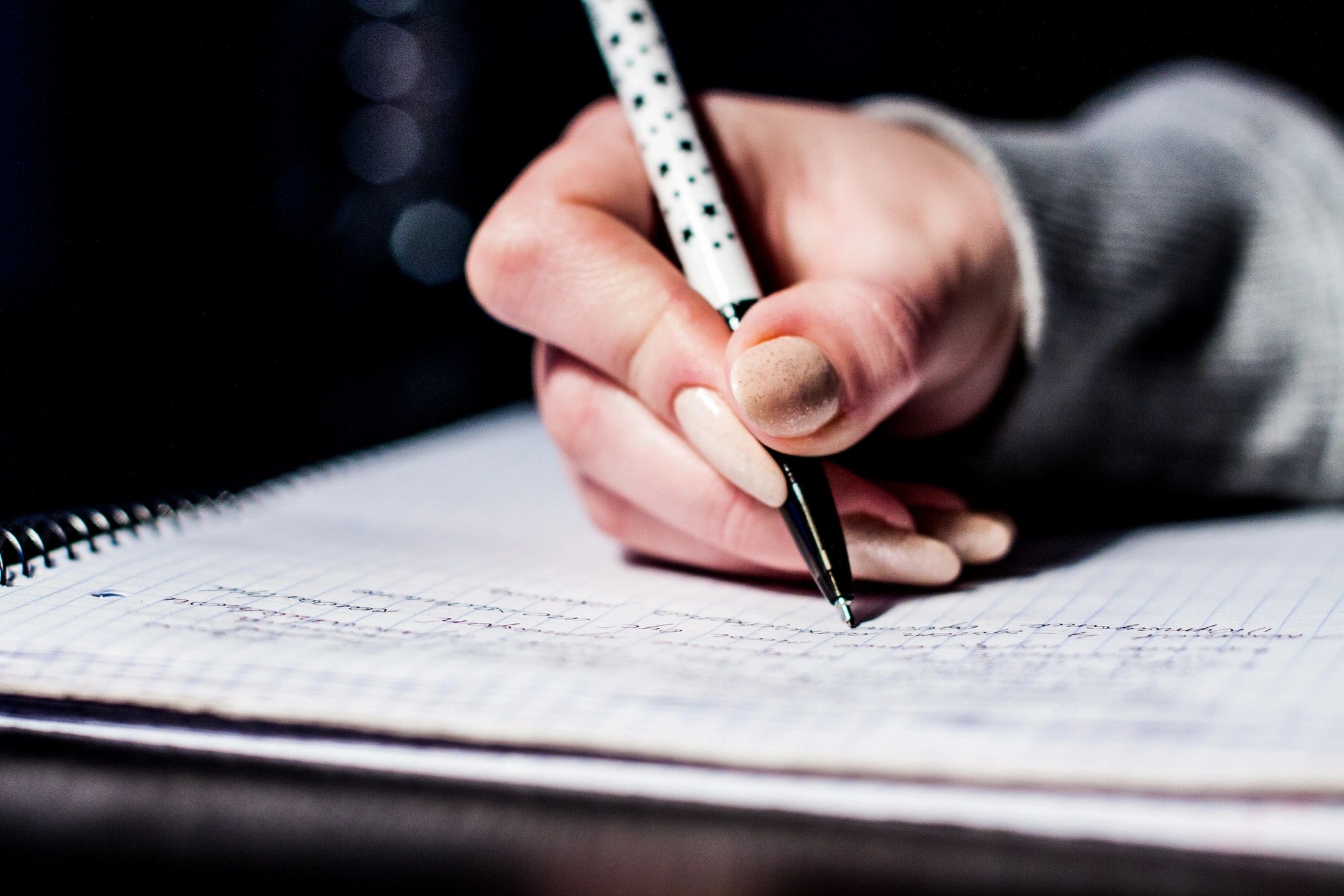 Hand holding pen and writing on paper